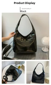 Detail view of glossy black hobo bag with wide strap and minimalist polished leather finish