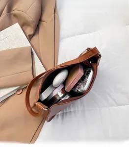 Close-up of brown crocodile texture bag interior with zipper pocket and makeup storage