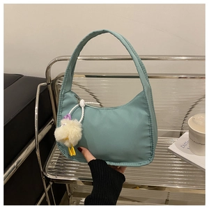 Detail of mint green crescent bag with a cute plush chick pendant for casual use
