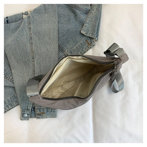 Détail de l'intérieur spacieux avec doublure beige du sac bandoulière en nylon gris foncé