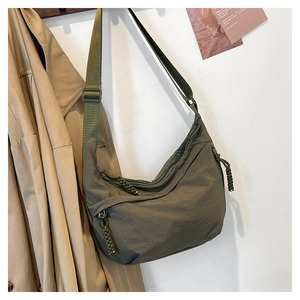 Détail de la besace en nylon vert armée montrant la bandoulière et la texture