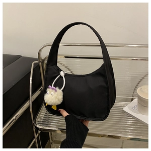 Minimalist black nylon underarm bag with cute plush pendant and secure zipper closure