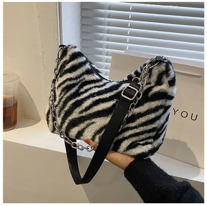 Detailed macro view of zebra pattern plush texture and silver metal chain strap on tote bag