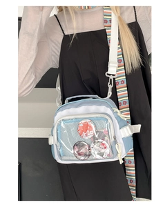 Détail du sac ITA bleu et blanc avec fenêtre transparente et bandoulière à fleurs