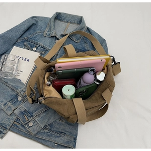 Macro view of large capacity corduroy tote bag showing spacious interior with personal items