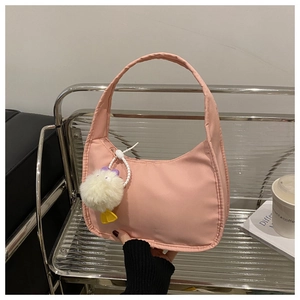Detailed close-up of pink nylon shoulder bag featuring a cute white plush duck charm