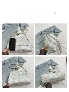 Détails de la broderie papillon et de la chaîne dorée sur le sac à bandoulière blanc