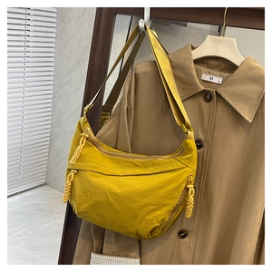 Détail du sac croissant en nylon gingembre avec zip tressé et large bandoulière