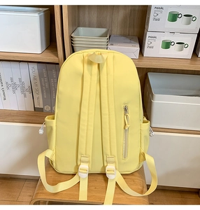 Rear view of light yellow backpack showing adjustable straps and hidden anti-theft pocket