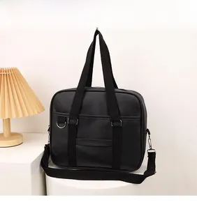 Detail of black Japanese style PU leather JK school bag with detachable strap and top handle