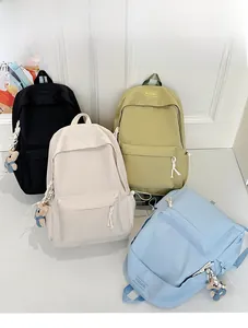 Detail of four colorful nylon backpacks with zipper pockets and plush bear charms
