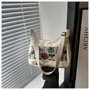 Close-up of stylish canvas tote bag with floral pattern stitching and adjustable shoulder strap