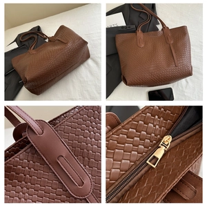 Detail view of brown woven tote bag showing golden zipper closure and elegant craftsmanship