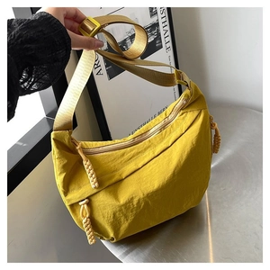 Détail du sac demi-lune jaune vif en nylon avec fermeture tissée et bandoulière