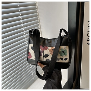 Detail showing the colorful floral woven texture and black PU leather stitching on the bag