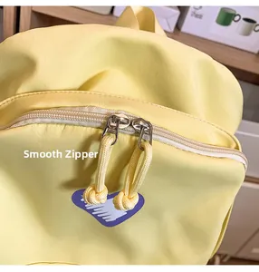 Close-up of smooth double metal zippers and heart pattern on the yellow student backpack