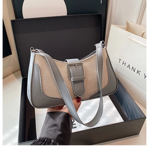 Detail view of woven leather bag with metallic buckle in elegant gift box