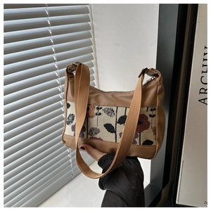 Detail view of khaki leather and jacquard canvas bag with dark vintage floral embroidery