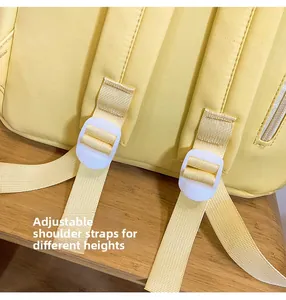 Detail view of adjustable yellow backpack shoulder straps with white plastic buckles