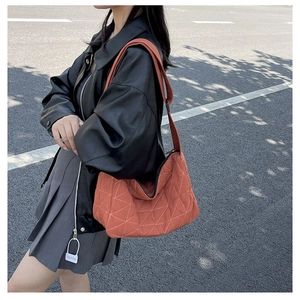 Detailed close-up of caramel quilted tote bag with geometric patterns for women