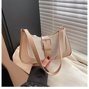 Detail of beige woven baguette bag with smooth faux leather trim and metallic buckle