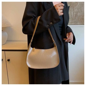 Detail of vintage beige hobo bag in oil-wax leather texture with gold zipper on a model