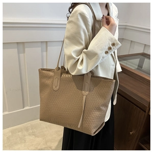 Detail of the elegant woven texture on this apricot large-capacity commuter tote bag