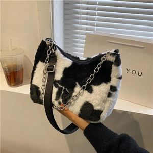 Fuzzy cow print tote bag with thick silver metal chain and adjustable strap in winter style