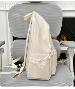 Close-up of beige waterproof backpack side pocket with adjustable drawstring and braided cord