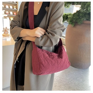 Detail view of burgundy quilted tote bag with diamond pattern and soft nylon texture