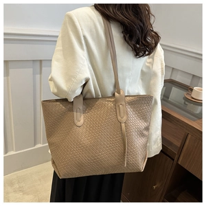 Detail of beige woven tote bag showing fine square texture and slim faux leather straps