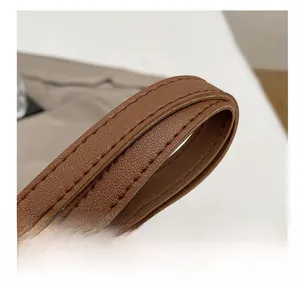 Détail de la bandoulière en cuir marron avec double couture et finition lisse élégante