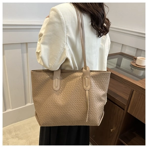Detail of light beige woven tote bag showing fine grid texture and large capacity