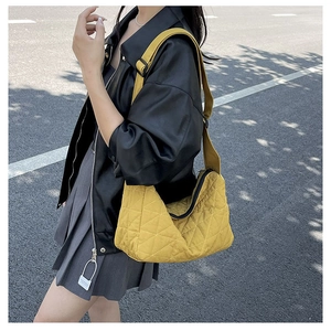 Detail of yellow quilted tote bag with diamond stitching and adjustable wide shoulder strap