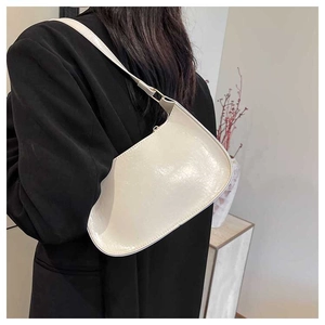 Minimalist cream white baguette bag in glossy leather shown from a side-view angle