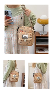 Détail d'un sac bandoulière beige à motif capybara avec sangle réglable sur un mannequin