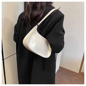 Minimalist creamy white baguette bag shown from the back perspective on a shoulder