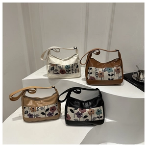 Close-up of four floral patchwork canvas handbags in assorted colors on display steps