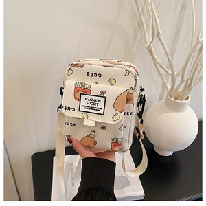 Détail d'un mini sac carré en toile avec des motifs de dessins animés et bandoulière