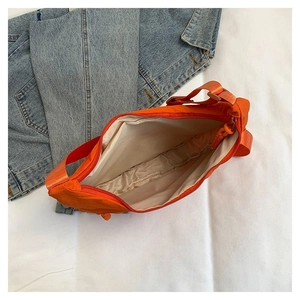 Vue détaillée du sac fourre-tout orange en nylon montrant la fermeture et la doublure