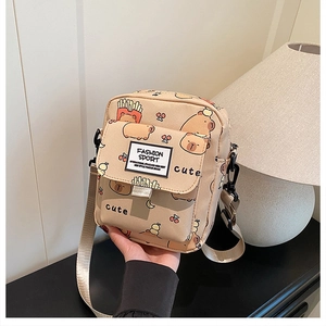 Détail d'un petit sac en toile beige avec imprimé capybara et bandoulière ajustable