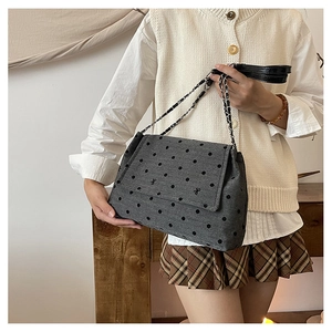 Sac bandoulière à pois avec bandoulière chaîne porté par un mannequin en style décontracté