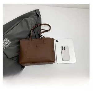 Detailed view of the brown leather tote bag with functional magnetic snap front pocket