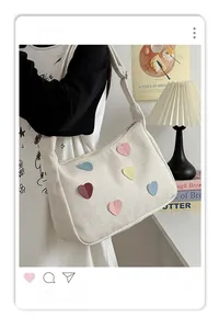 Detail of herringbone canvas tote bag with multi-colored heart patches and wide strap