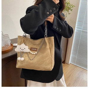 Détail du sac cabas kaki avec chaîne en métal, perles et pendentif nuage en peluche