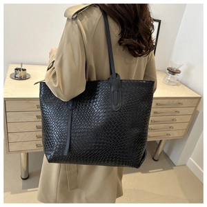 Close-up showing texture of the black woven leather tote bag for daily commute and travel