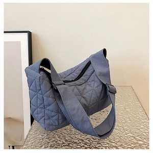 Detail of blue quilted tote bag with diamond pattern on water ripple base