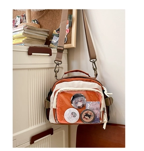 Détail du sac ita en toile orange avec fenêtre transparente pour badges et cartes anime