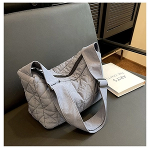 Close-up of blue-grey quilted nylon tote bag with rhombus patterns on a dark chair