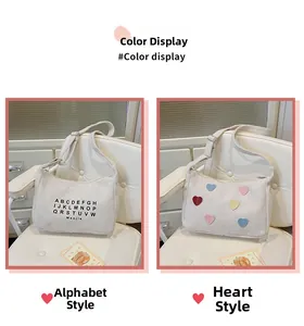 Detail view of cream canvas tote bags with letter prints and colorful heart patches